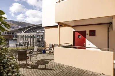 a patio with chairs and a red door on a building at City apartment with balcony and 3 bedrooms! in Bergen