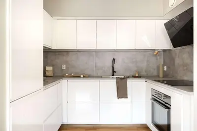 a white kitchen with white cabinets and a sink at City apartment with balcony and 3 bedrooms! in Bergen