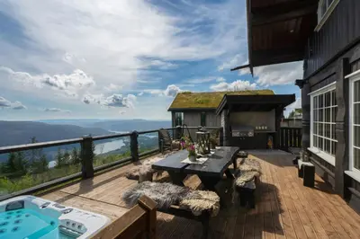 a deck with a table and chairs and a pool at Large Cabin For 20 By Norefjell Ski Resort in Noresund