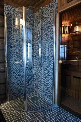 a glass shower in a bathroom with blue tiles at Fjellhytte Med Panorama På Toppen Av Norefjell in Noresund