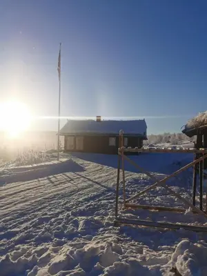 a building with a flag in the snow at Leilighet på fjellet nær Geilo in Hol