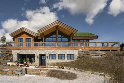 a house with a green roof on a hill at Designer Cabin For 16 With Spa In Turufjell in Flå