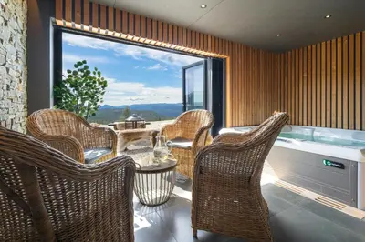 a room with chairs and a table and a large window at Designer Cabin For 16 With Spa In Turufjell in Flå