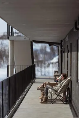 two people are sitting in chairs on a porch at Kikut1010 Skurdalsvegen 107 in Hol