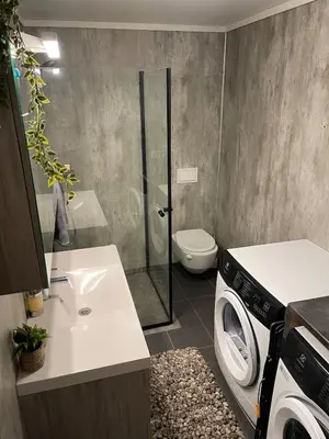 a bathroom with a washing machine and a washer at Modern apartment - Balcony, Parking, BBQ in Vossevangen