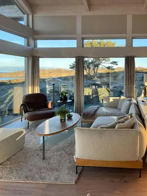 a living room with couches and a large window at Cottage With Sunny Terraces And Sea Views in Lysøysund