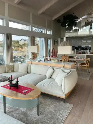 a living room with a couch and a table at Cottage With Sunny Terraces And Sea Views in Lysøysund