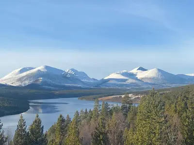 a view of a lake with snow covered mountains at Live in the realm of the musk oxen on Dovrefjell in Hjerkinn