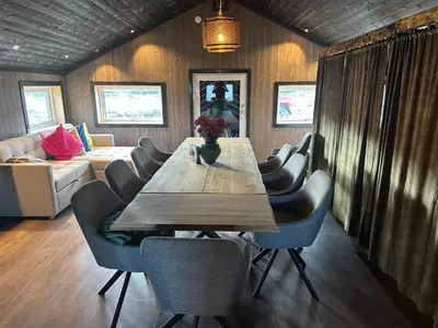 a dining room with a wooden table and chairs at Sits in the middle of Reinheimen and Dovrefjell Rondane in Dombås