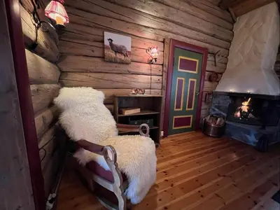 a room with two chairs and a fireplace in a log cabin at Idyllisk feriested in Gol
