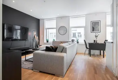 a living room with a couch and a table and a television at Spacious 2-room in the city center, easy access to everything in Ålesund