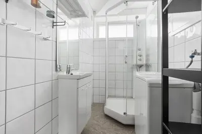 a white bathroom with a toilet and a sink at Central 4 room apartment in Bergen