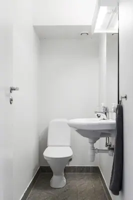 a bathroom with a white toilet and a sink at Central 4 room apartment in Bergen