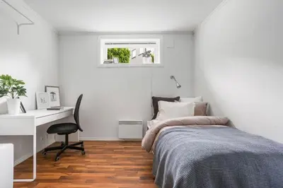 a bedroom with a bed and a desk and a chair at Central 4 room apartment in Bergen