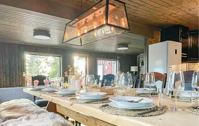 a long wooden table with plates and glasses on it at Lovely Home In Sjusjøen With Sauna in Sjusjøen