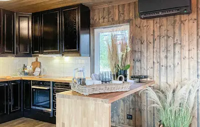 a kitchen with wooden cabinets and a basket on a counter at Lovely Home In Sjusjøen With Sauna in Sjusjøen