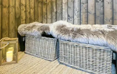 two wicker baskets with fur on them next to a fence at Lovely Home In Sjusjøen With Sauna in Sjusjøen