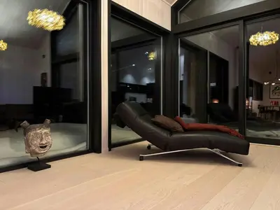 a black leather chair in a room with windows at Architect Cabin With Ski-In Near Trysil in Trysil