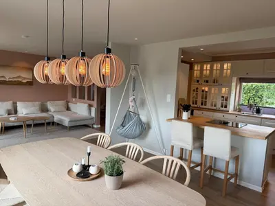 a kitchen and living room with a table and chairs at Spacious house with a beautiful view for rent in Ålesund