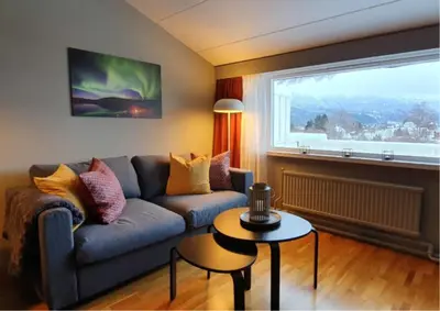 a living room with a couch and a window at Kvikne Fjellhotell & Kafé in Tynset