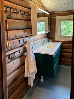 a bathroom with a sink and a wooden wall at Log Cabin With 360-Degree Views Near Trysil in Trysil