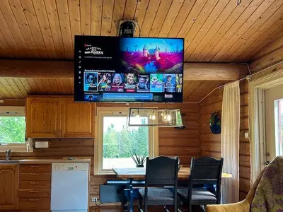a tv on the ceiling of a kitchen with a table at Log Cabin With 360-Degree Views Near Trysil in Trysil