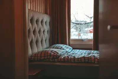 a bed sitting in front of a window at Close to cross-country skiing, slalom slope and mountains - Soltun Geilo! in Hol