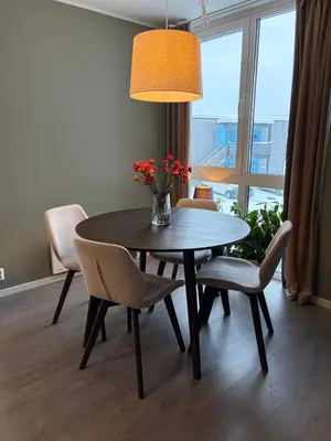 a dining room table with chairs and a vase with flowers at Modern apartment in Raufoss in Raufoss