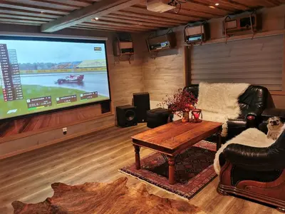 a living room with a tv and a couch and a table at Cozy family cottage with a view