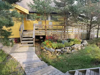 a wooden walkway leading to a house with a fence at Cozy family cottage with a view