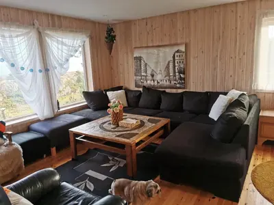 a living room with a couch and a table at Cozy family cottage with a view