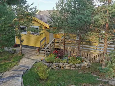 a yellow tiny house with a wooden fence at Cozy family cottage with a view