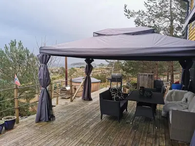 a blue canopy on top of a wooden deck at Cozy family cottage with a view