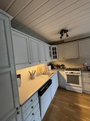 a kitchen with white cabinets and a counter top at Etterstad in Lii
