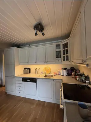 a kitchen with white cabinets and a ceiling at Etterstad in Lii