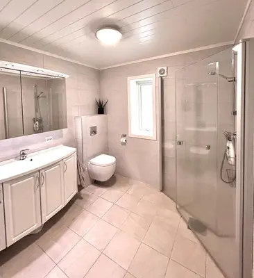 a bathroom with a toilet and a sink and a shower at High standard, large cabin with amazing view in Stryn