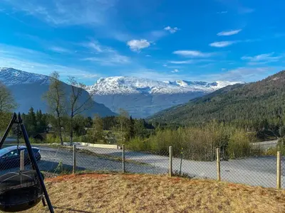 a fence with a view of snow covered mountains at High standard, large cabin with amazing view in Stryn