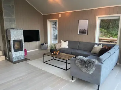 a living room with a couch and a fireplace at High standard, large cabin with amazing view in Stryn