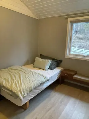 a small bedroom with a bed and a window at Bolig på Kaupanger in Kaupanger