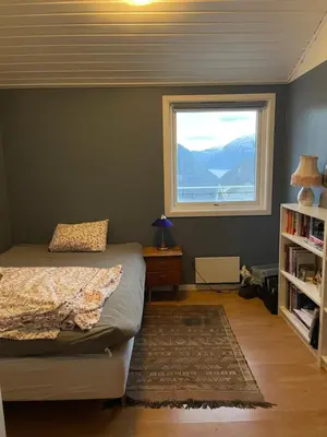 a bedroom with a bed and a window at Bolig på Kaupanger in Kaupanger