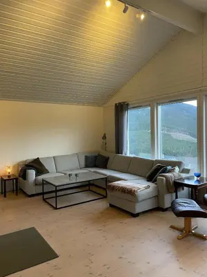 a living room with a couch and a table at Bolig på Kaupanger in Kaupanger