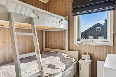 a bedroom with a bunk bed and a window at Modern family cabin with ski in out, central location in Beitostølen in Beitostøl