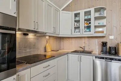 a kitchen with white cabinets and a sink at Modern family cabin with ski in out, central location in Beitostølen in Beitostøl