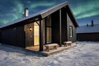 a small building with a bench in the snow at Modern family cabin with ski in out, central location in Beitostølen in Beitostøl