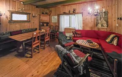 a living room with a red couch and a table at Beautiful Home In Lampeland With Sauna in Lampeland