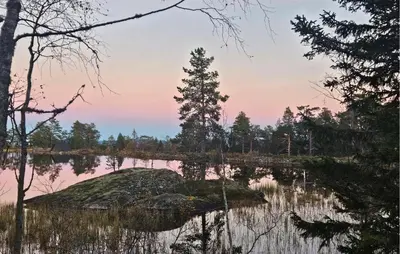 a rock in the middle of a lake at sunset at Beautiful Home In Lampeland With Sauna in Lampeland