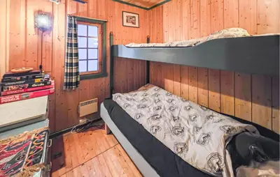 a bedroom with a bunk bed in a wooden cabin at Beautiful Home In Lampeland With Sauna in Lampeland