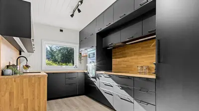 a kitchen with black and white cabinets and a window at Charming newly renovated house in city centre in Verdal