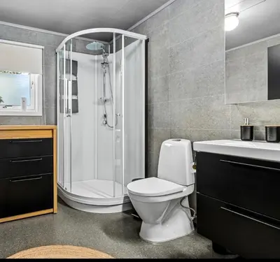 a bathroom with a shower and a toilet and a sink at Charming newly renovated house in city centre in Verdal
