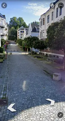 a cobblestone street with arrows pointing in different directions at Beautiful apartment in the heart of Bergen in Bergen